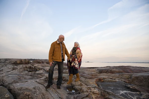 Pareja madura caminando sobre rocas — Foto de Stock