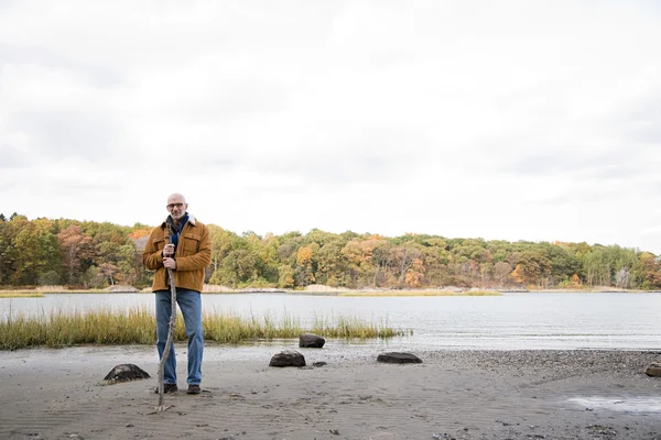 Hombre de pie cerca de un lago y un bosque — Foto de Stock