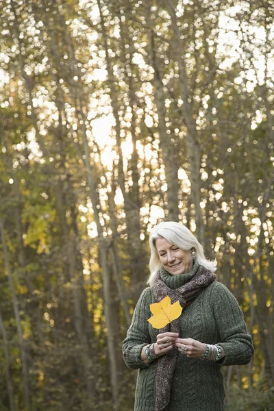 Senior woman holding a leaf — Stock Photo, Image