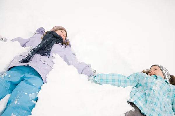 Meninas deitadas na neve se divertindo — Fotografia de Stock