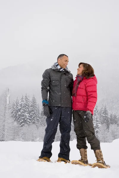 Reife Frau steht im Schnee — Stockfoto