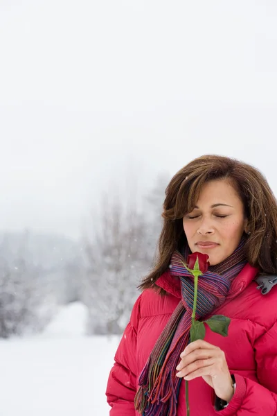 Mogen kvinna att lukta en ros — Stockfoto