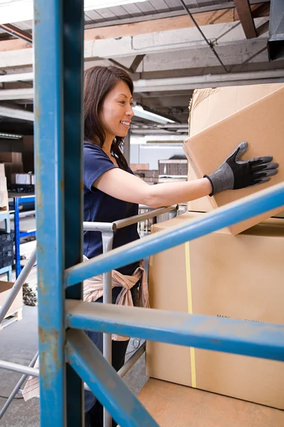 Warehouse worker taking carbdoard box — Stock Photo, Image