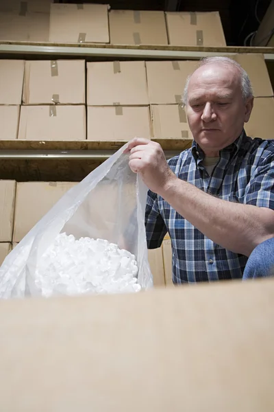 Man with bag of packing peanuts — Stock Photo, Image