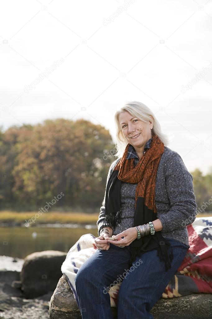 Senior woman sitting on rocks