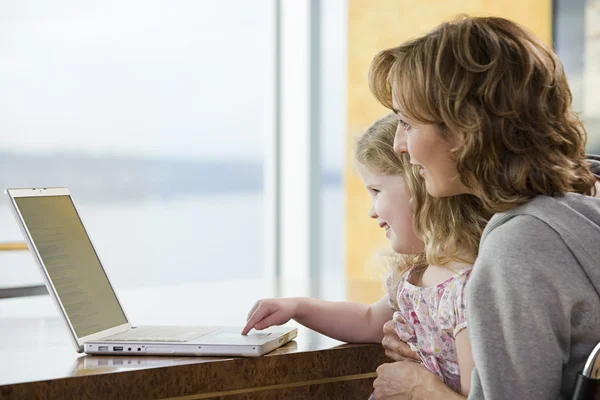 Mor och dotter använder en bärbar dator — Stockfoto