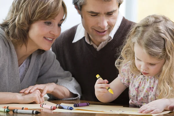 Padres ayudando a su hija a dibujar — Foto de Stock