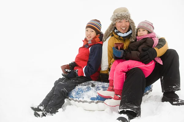 Far och barn med varm dryck i snö — Stockfoto