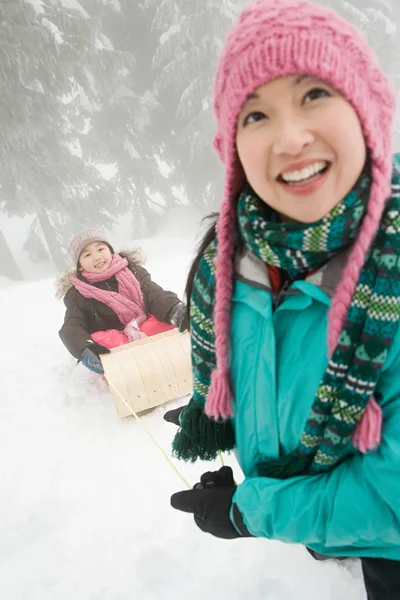 母亲和女儿与雪橇 — 图库照片