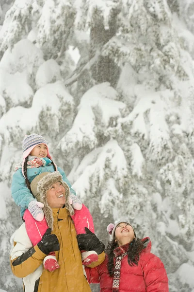 Flicka och föräldrar i snö — Stockfoto