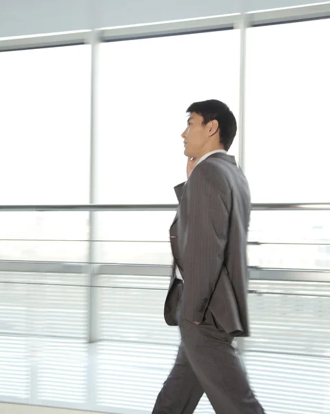 Businessman walking with mobile phone — Stock Photo, Image