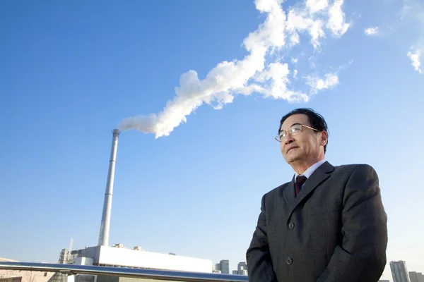 Homme d'affaires devant Smokestack — Photo