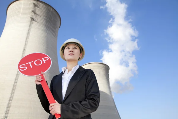 Engineer in front of cooling towers with stop sign — Stock Photo, Image