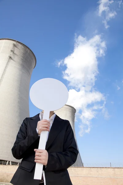 Engineer in front of cooling towers with sign — Stock Photo, Image