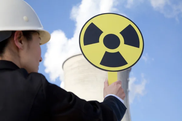 Engineer in front of cooling towers with sign — Stock Photo, Image