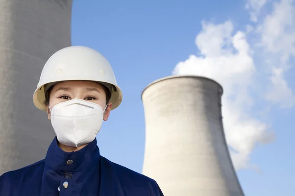 Werknemer met veiligheidshelm en masker op elektriciteitscentrale — Stockfoto