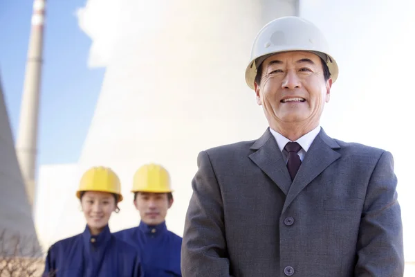 Businessman and workers in hardhats — Stock Photo, Image