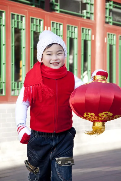 Niño sosteniendo linterna roja en el patio — Foto de Stock