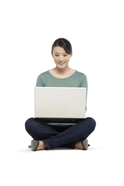 Jovem mulher usando um computador portátil — Fotografia de Stock