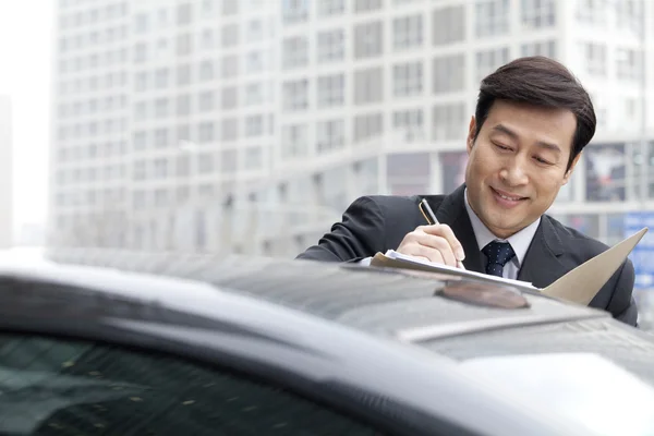 Businessman working on car — Stock Photo, Image