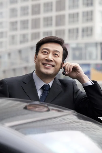 Businessman talking on phone outdoors — Stock Photo, Image