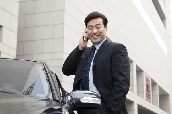 Businessman talking on phone outdoors — Stock Photo, Image