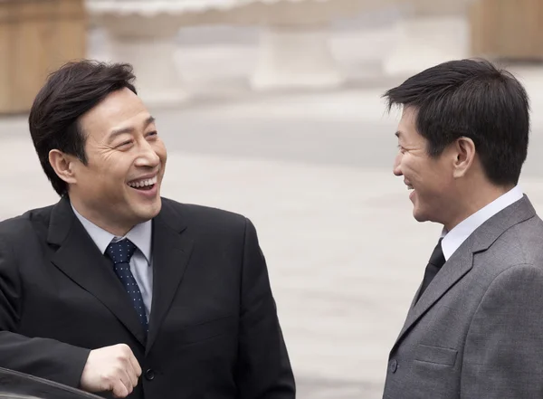Businessmen smiling to each other — Stock Photo, Image