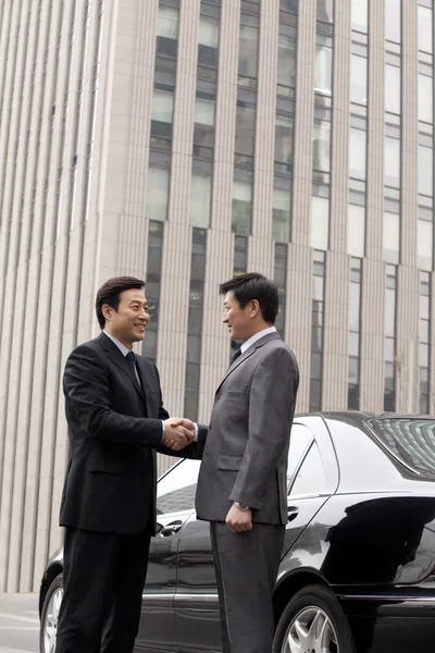 Dois homens de negócios apertando as mãos ao ar livre — Fotografia de Stock