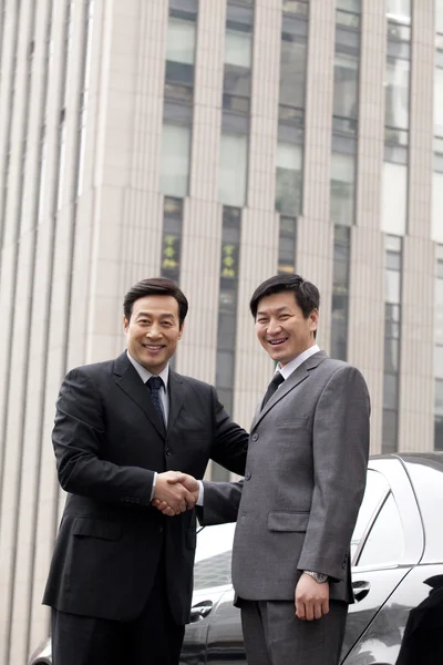 Two businessmen shaking hands outdoors — Stock Photo, Image