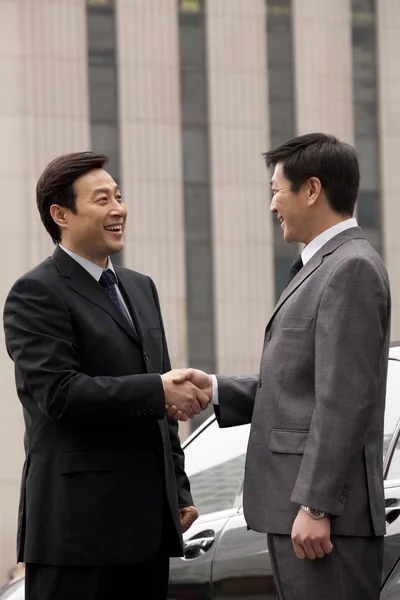 Two businessmen shaking hands outdoors — Stock Photo, Image