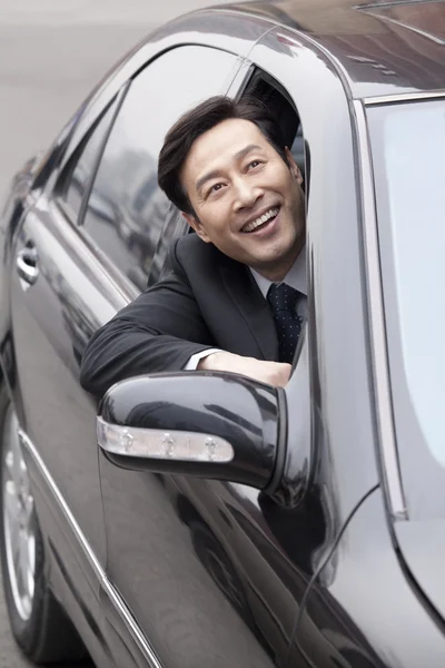 Businessman looking out car window — Stock Photo, Image