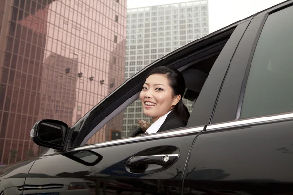 Mujer de negocios mirando por la ventana del coche — Foto de Stock