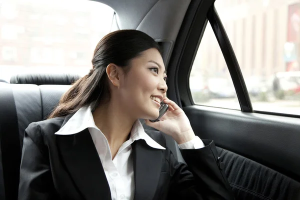 Businesswoman in a car on the phone — Stock Photo, Image