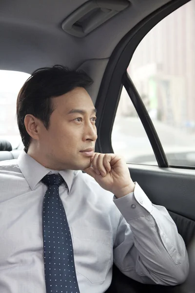 Hombre de negocios mirando por la ventana del coche — Foto de Stock