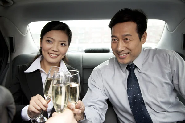 Obchodní lidé opékání šampaňské zadní část vozu — Stock fotografie