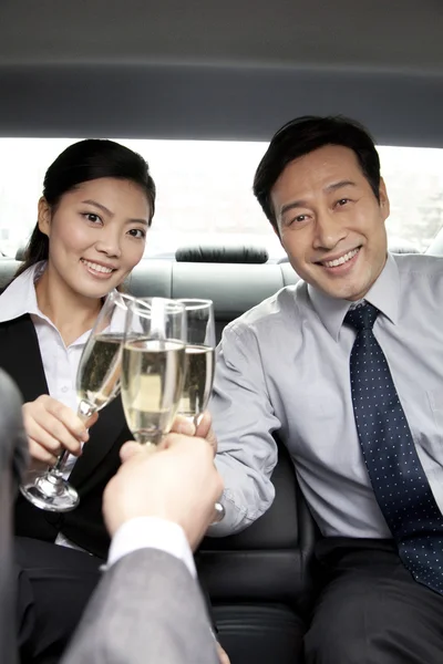 Mensen uit het bedrijfsleven champagne achterkant auto roosteren — Stockfoto