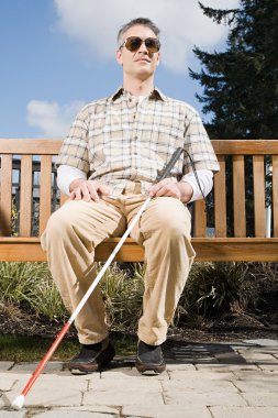 Kör adam bankta oturuyor.