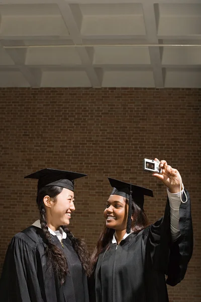 Две выпускницы фотографируют — стоковое фото