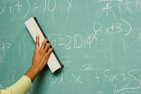 Person removing formulas from the blackboard — Stock Photo, Image