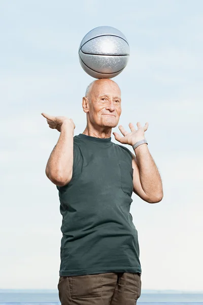 Man balancing basketbal op zijn hoofd — Stockfoto