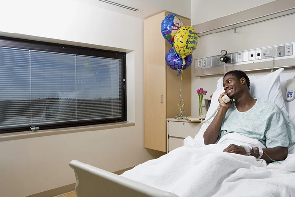 Patient parlant au téléphone dans un lit d'hôpital — Photo