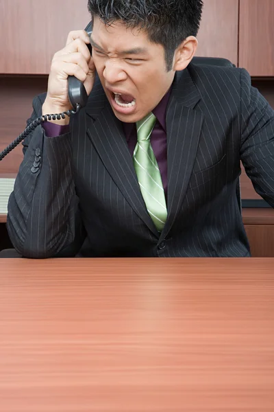 Businessman shouting down phone — Stock Photo, Image