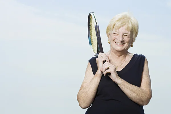 Старшая женщина с теннисной ракеткой — стоковое фото
