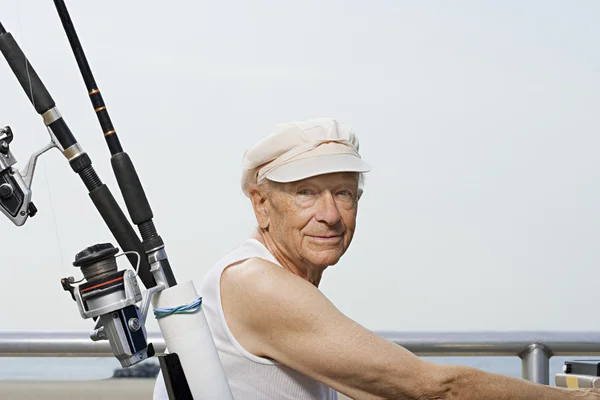 Starší muž s rybářský prut — Stock fotografie