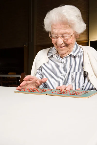 Mulher sênior jogando bingo — Fotografia de Stock