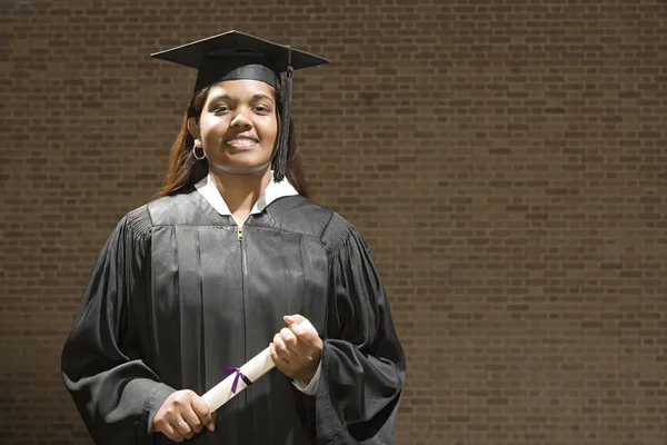 Жінка випускниця тримає диплом — стокове фото