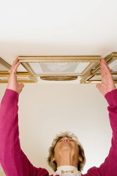 Woman adjusting picture frames — Stock Photo, Image