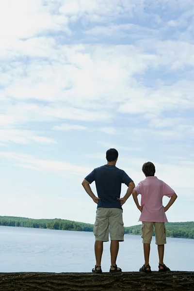 Vader en zoon kijken naar lake — Stockfoto