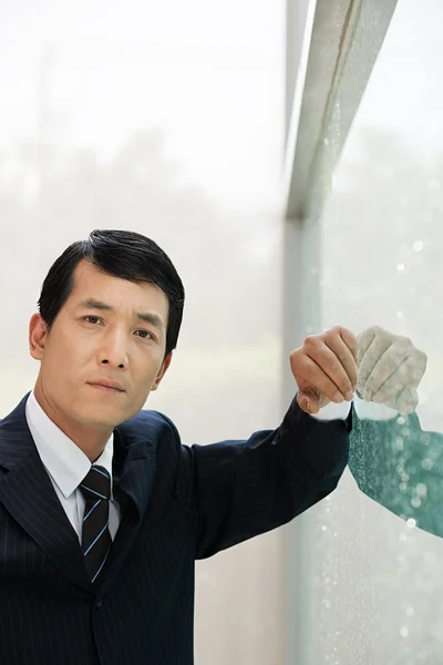 Japanse zakenman leunend op een venster — Stockfoto