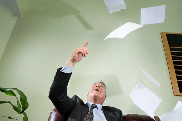 Homme d'affaires jetant du papier dans les airs — Photo